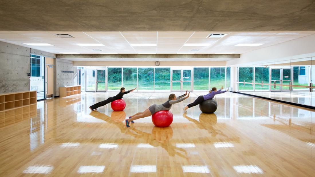 Three women using yoga balls in a studio