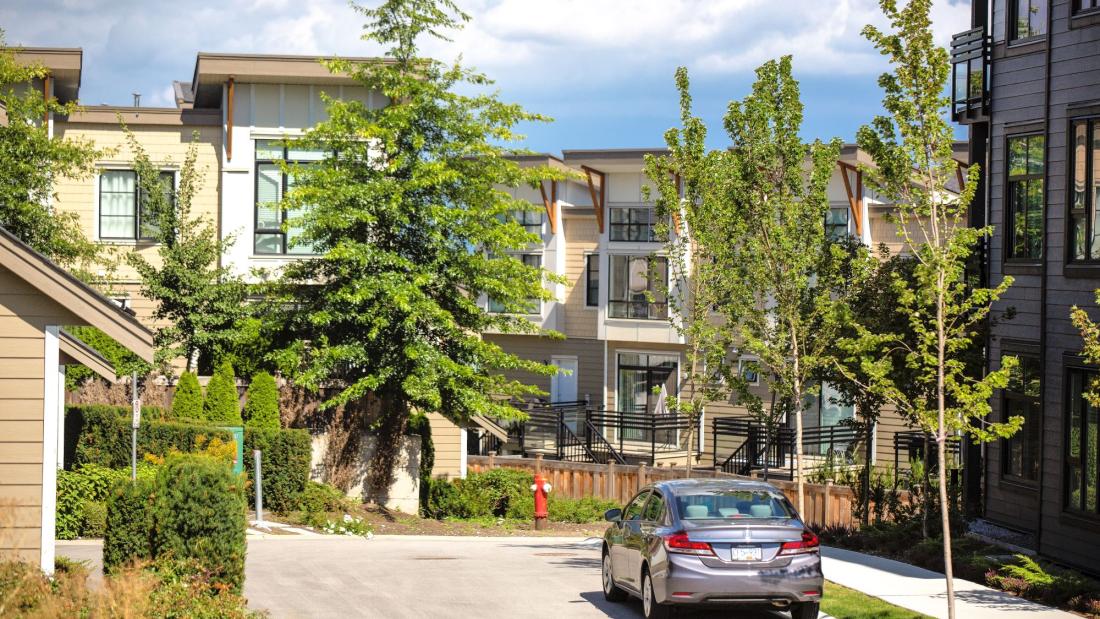 Beige condo low rises with green trees