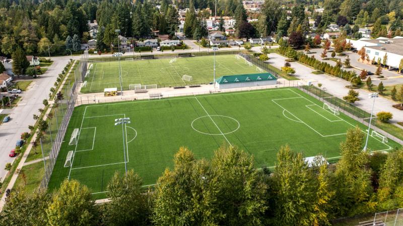 Aerial view of two athletic fields with cityscape in the background