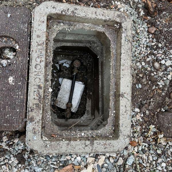 A crooked in-ground water meter