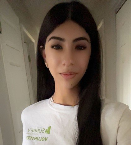 sapriya-v-volunteer.jpg Woman in a white “Surrey Volunteer” shirt taking a selfie in a hallway.